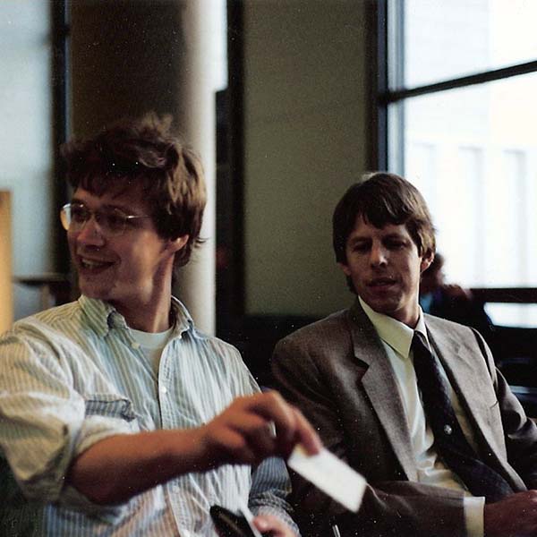 Ralph showing business card as Shihan Brian Workman watches.